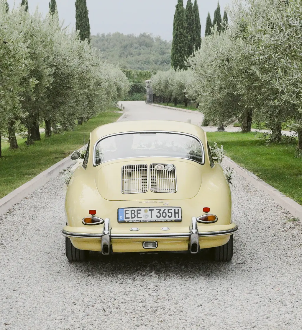 Ein klassischer Porsche steht in den grünen Weinbergen bei Tenuta La Presa.