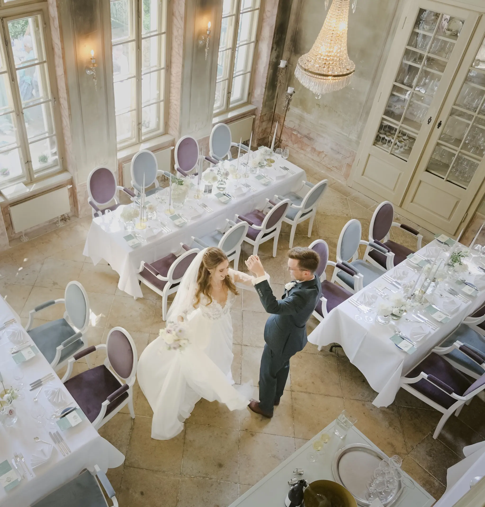 Inniger Moment des Brautpaars während einer Drehung im Saal zwischen den Gästetischen.