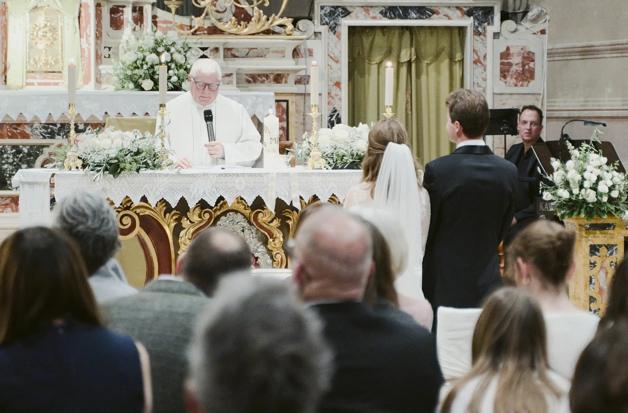 Kirchliche Trauung des Brautpaars vor dem Altar in der Chiesa Parrocchiale dei Santi Pietro e Paolo.