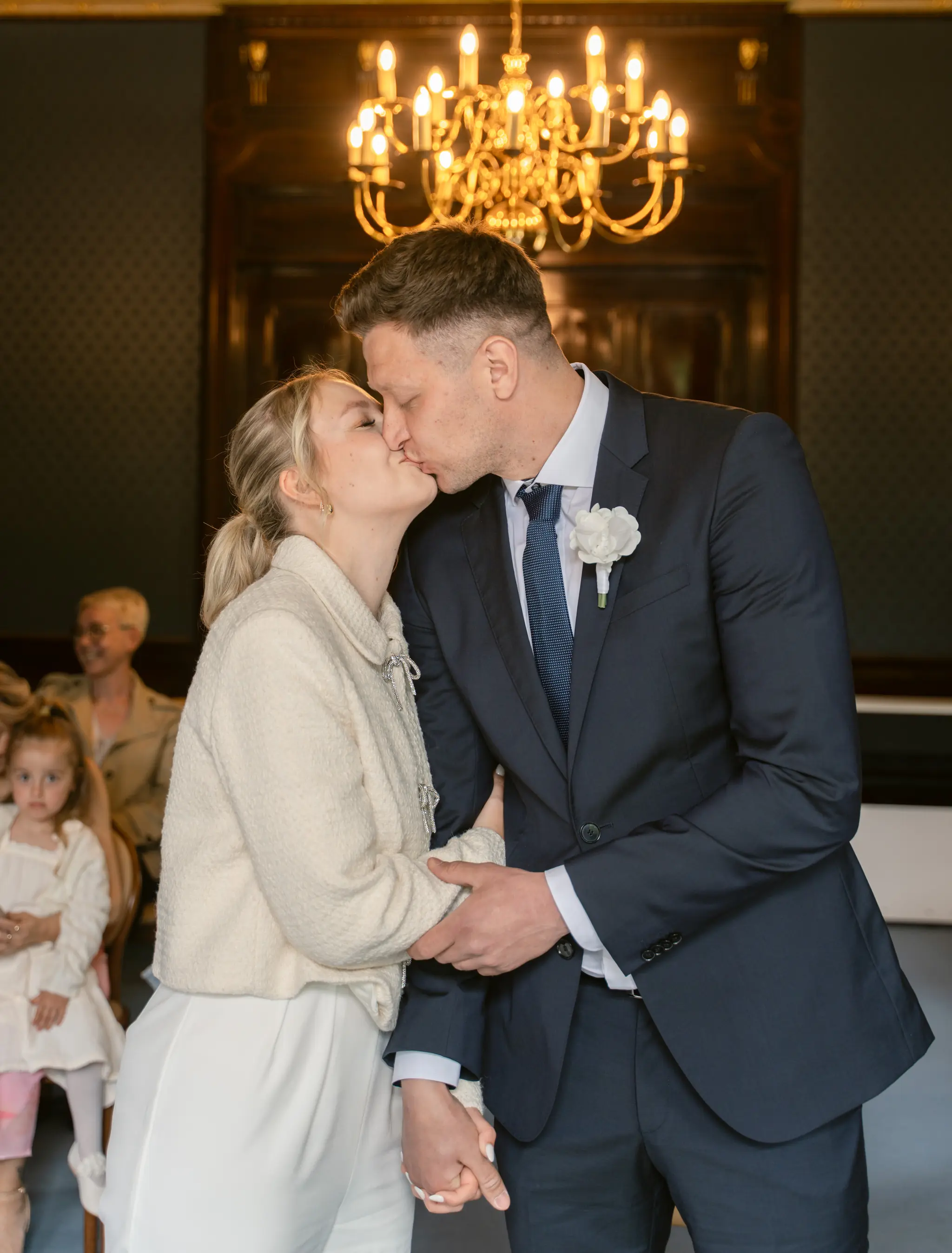 Inniger Moment: Das Brautpaar hält sich an den Händen und küsst sich während der Zeremonie in der Villa Weigang.