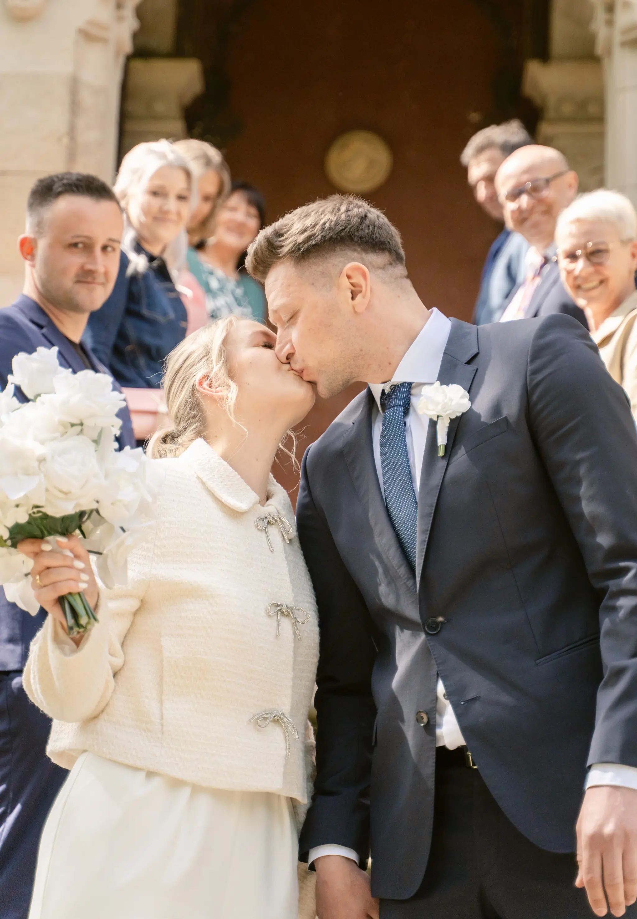 Innige Nahaufnahme: Das Paar küsst sich glücklich nach der Trauung vor dem Portal des Standesamts Goetheallee.