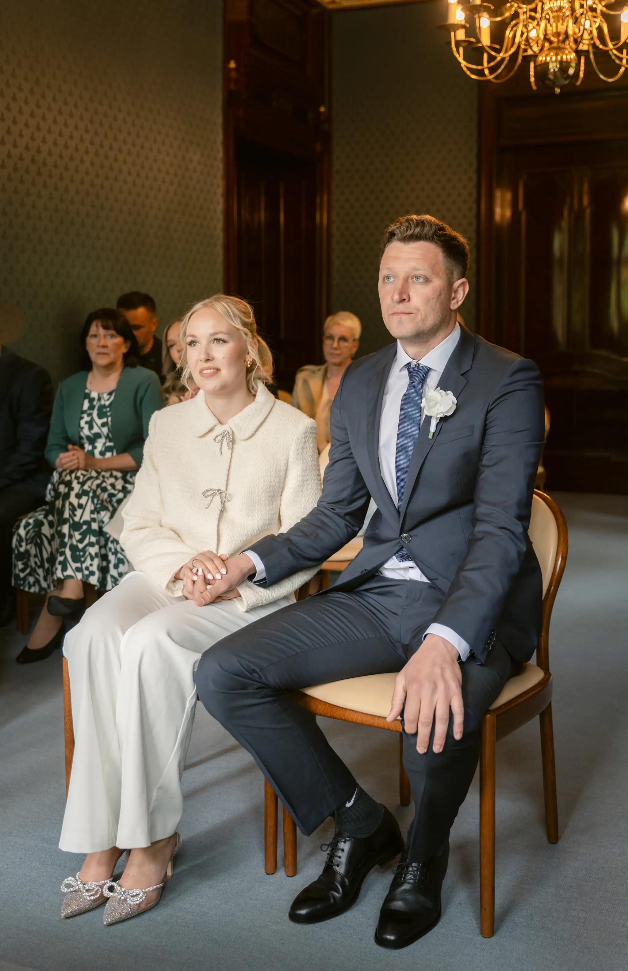 Das Brautpaar sitzt während der feierlichen Zeremonie im hellen Trausaal des Standesamts Goetheallee.