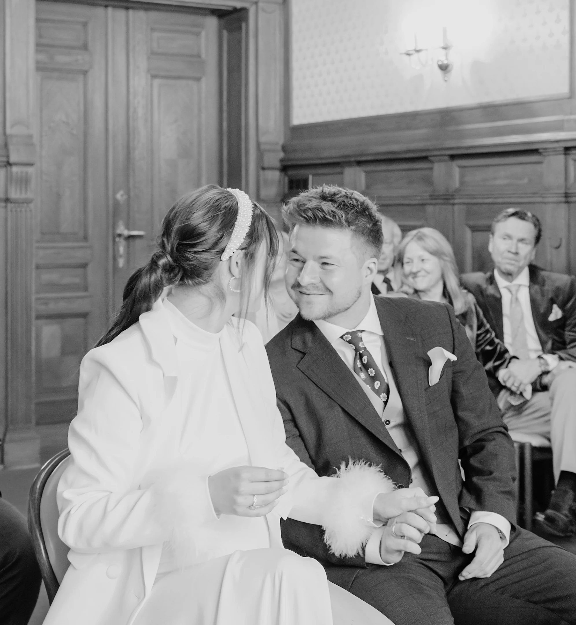 Schwarz-Weiß-Aufnahme des lachenden Brautpaares, das den Moment ihrer Hochzeit in der Villa Weigang sichtlich genießt.