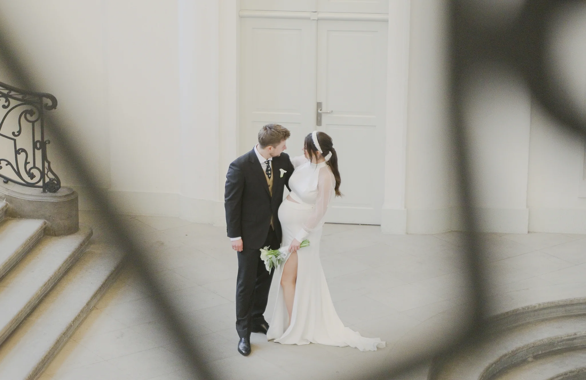 Das Brautpaar posiert innig auf der hellen Treppe im Landhaus Dresden für ein zeitloses Hochzeitsfoto nach der Trauung in der Villa Weigang.