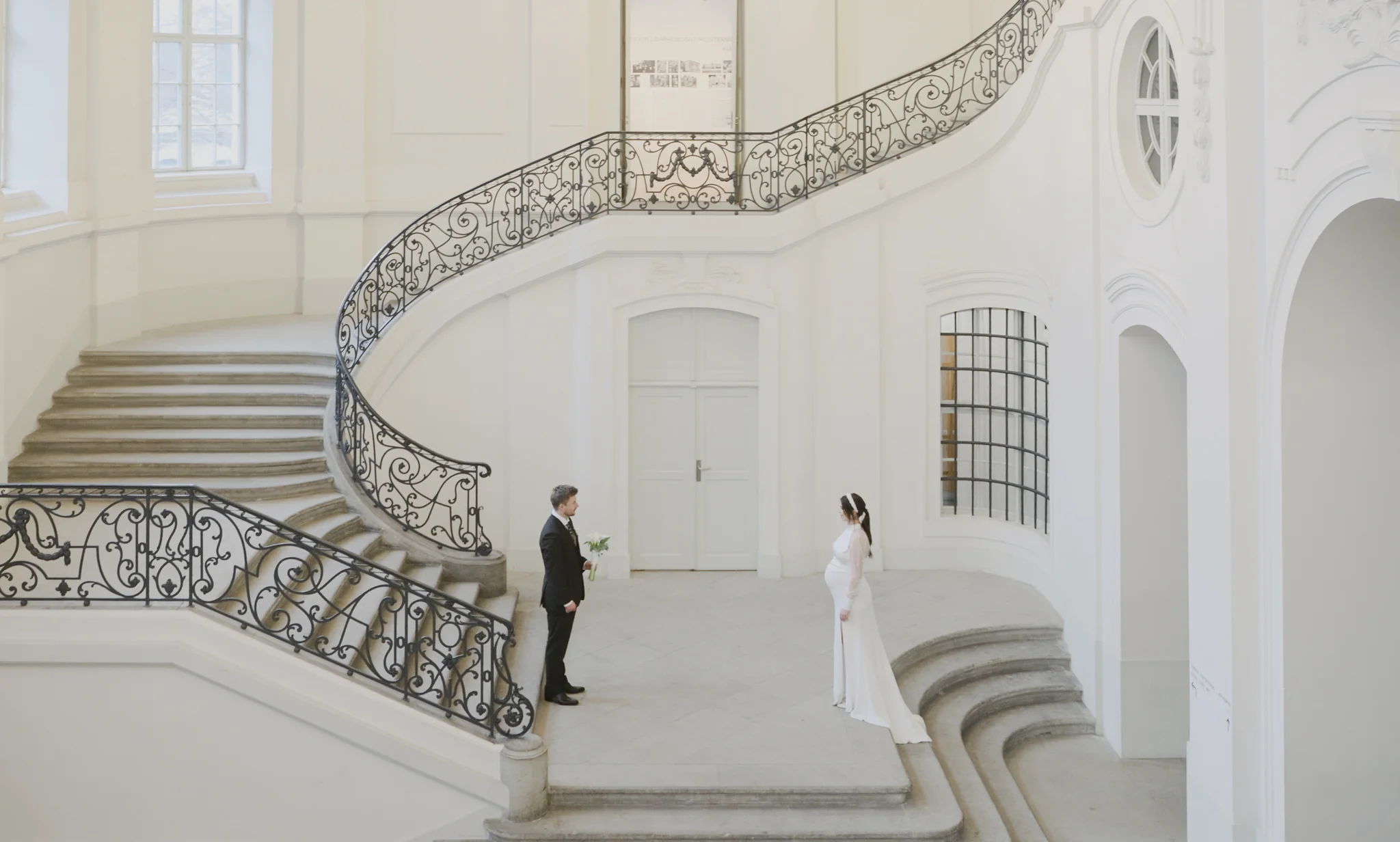 Weitwinkelaufnahme des Brautpaares im imposanten, hellen Treppenhaus des Landhauses Dresden bei der Villa Weigang.