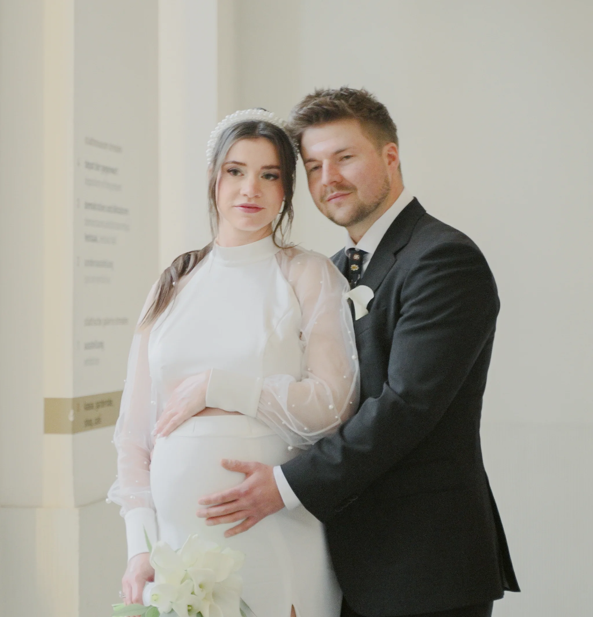 Innige Nahaufnahme des Brautpaares im Landhaus Dresden; der Bräutigam hält liebevoll den Babybauch der Braut in der Villa Weigang.